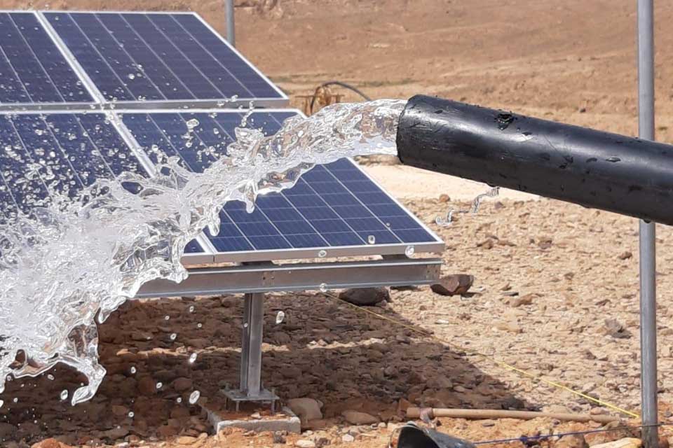 A pipe with flowing water and a solar panel in a development project in Yemen.