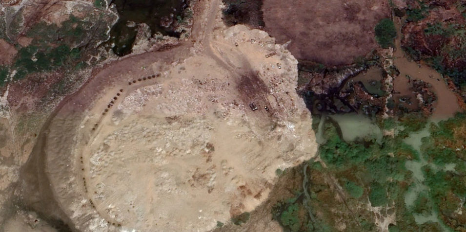 aden_dumpsite_960 The satellite image shows a circular mounded dump spreading over a wetland habitat and creeks.