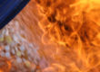 A blurred close up image shows white pills being consumed by orange flames.